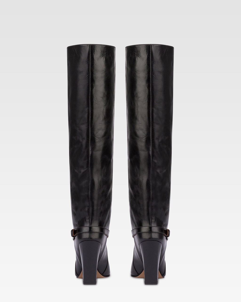 Tall, knee-high boots in shiny black vintage leather