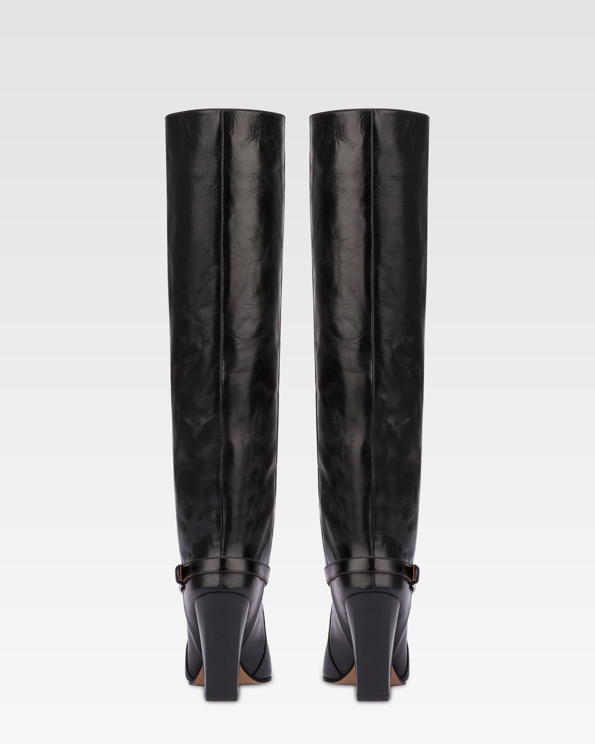 Tall, knee-high boots in shiny black vintage leather