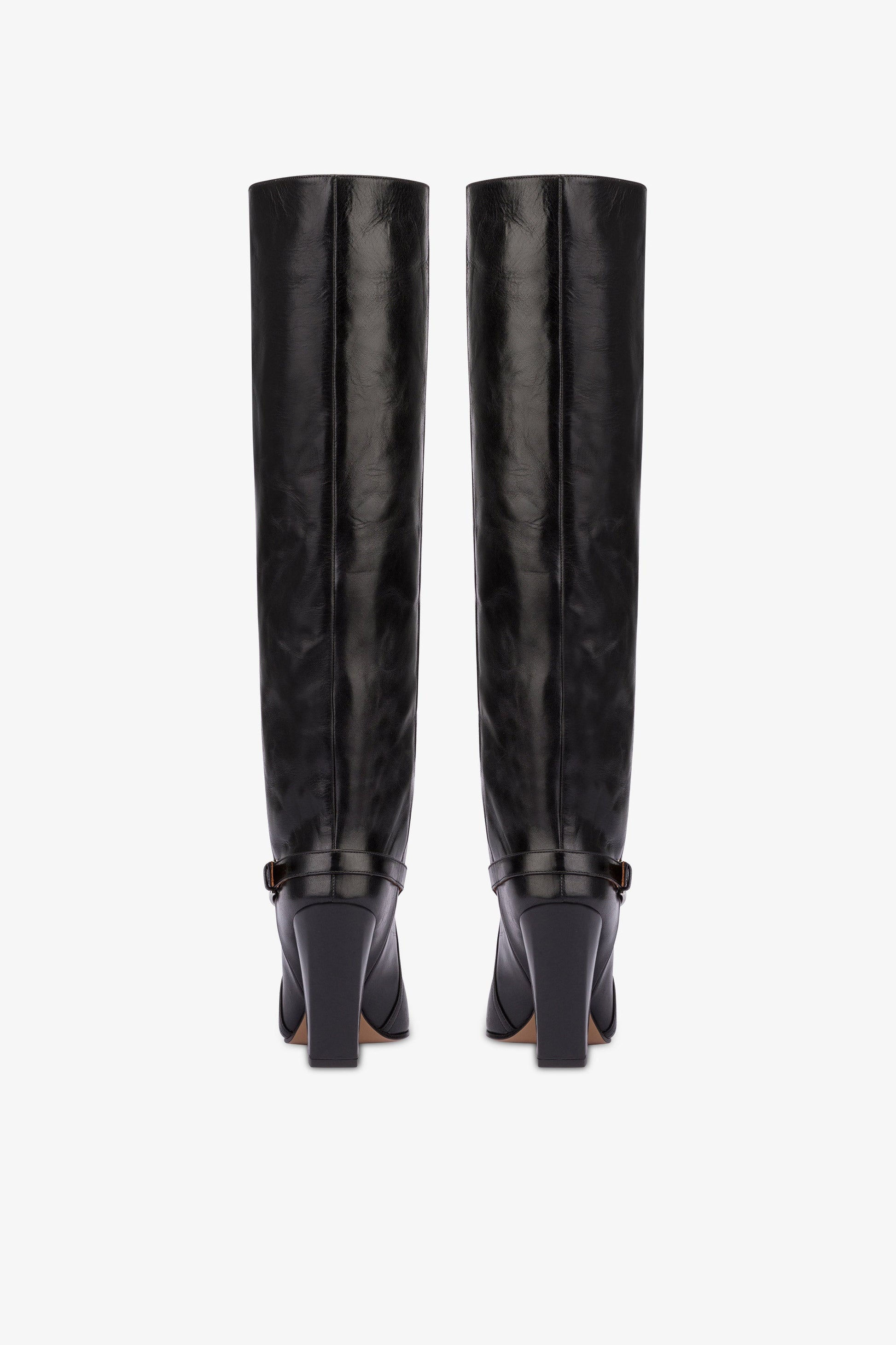 Tall, knee-high boots in shiny black vintage leather