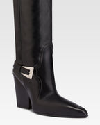 Tall, knee-high boots in shiny black vintage leather