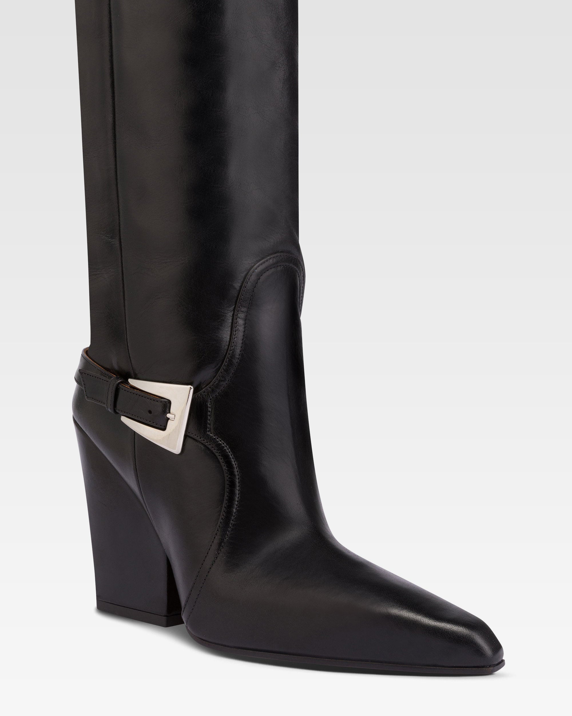 Tall, knee-high boots in shiny black vintage leather