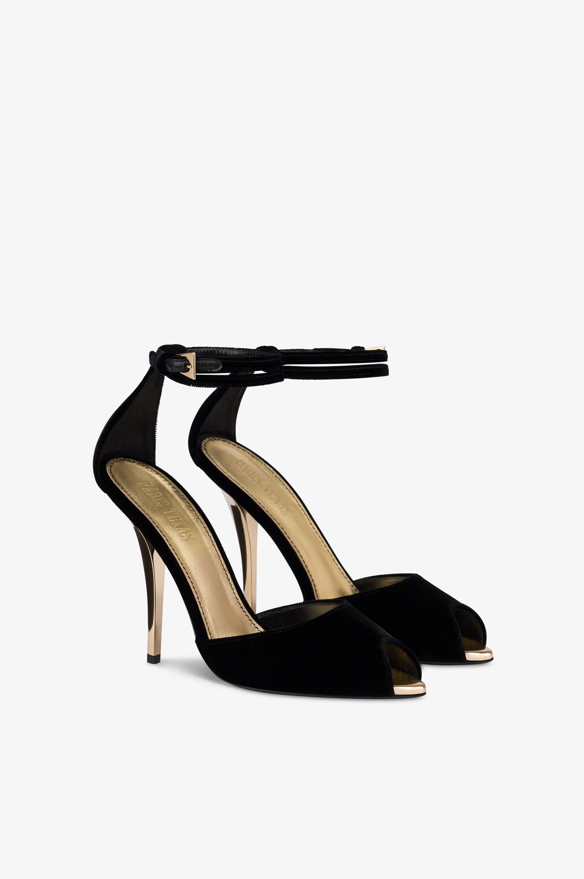 Sandalias de terciopelo de color negro con detalles dorados.