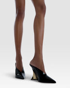 Sabots in black and gold patent leather