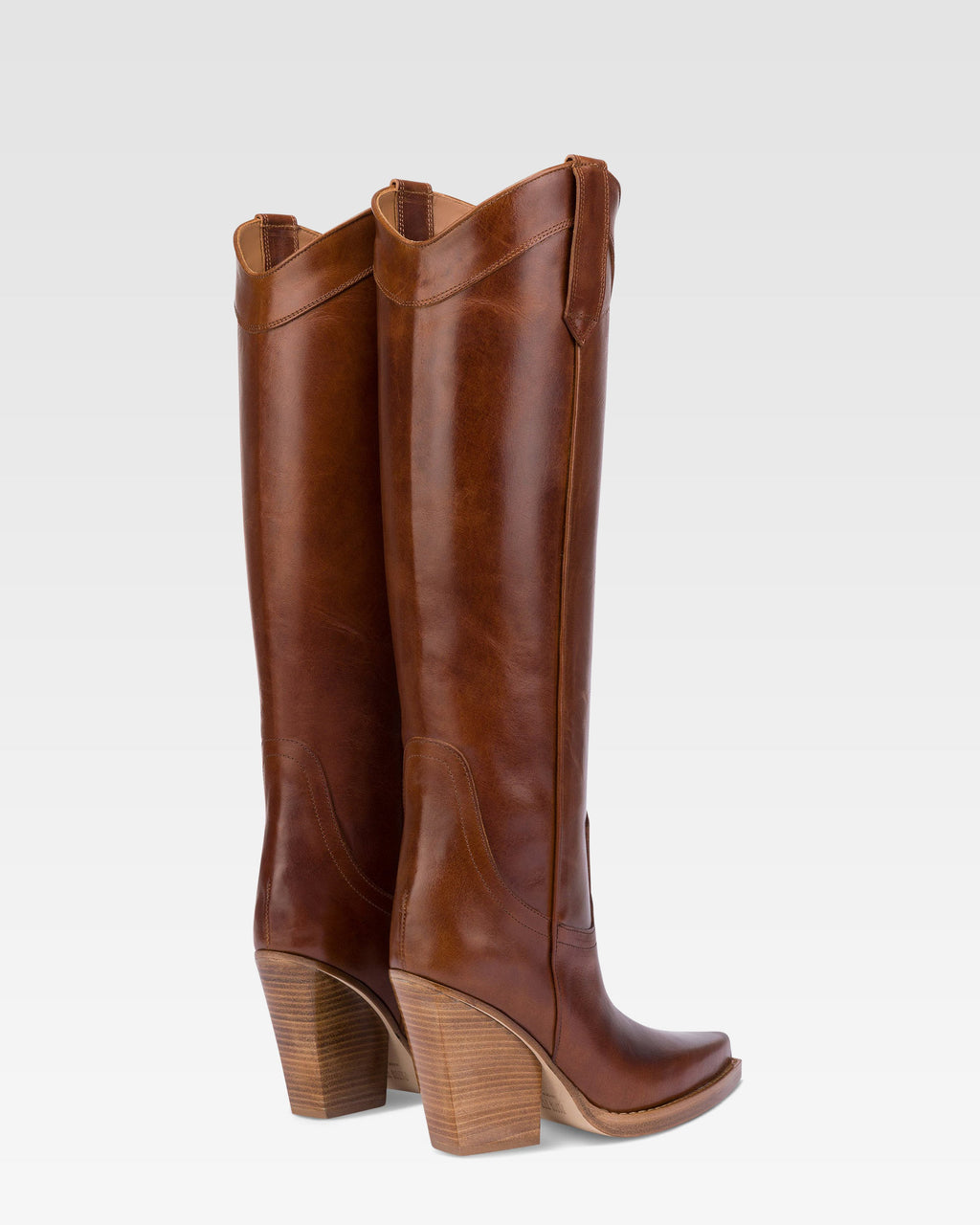 Pointed knee-high boots in shiny vintage leather