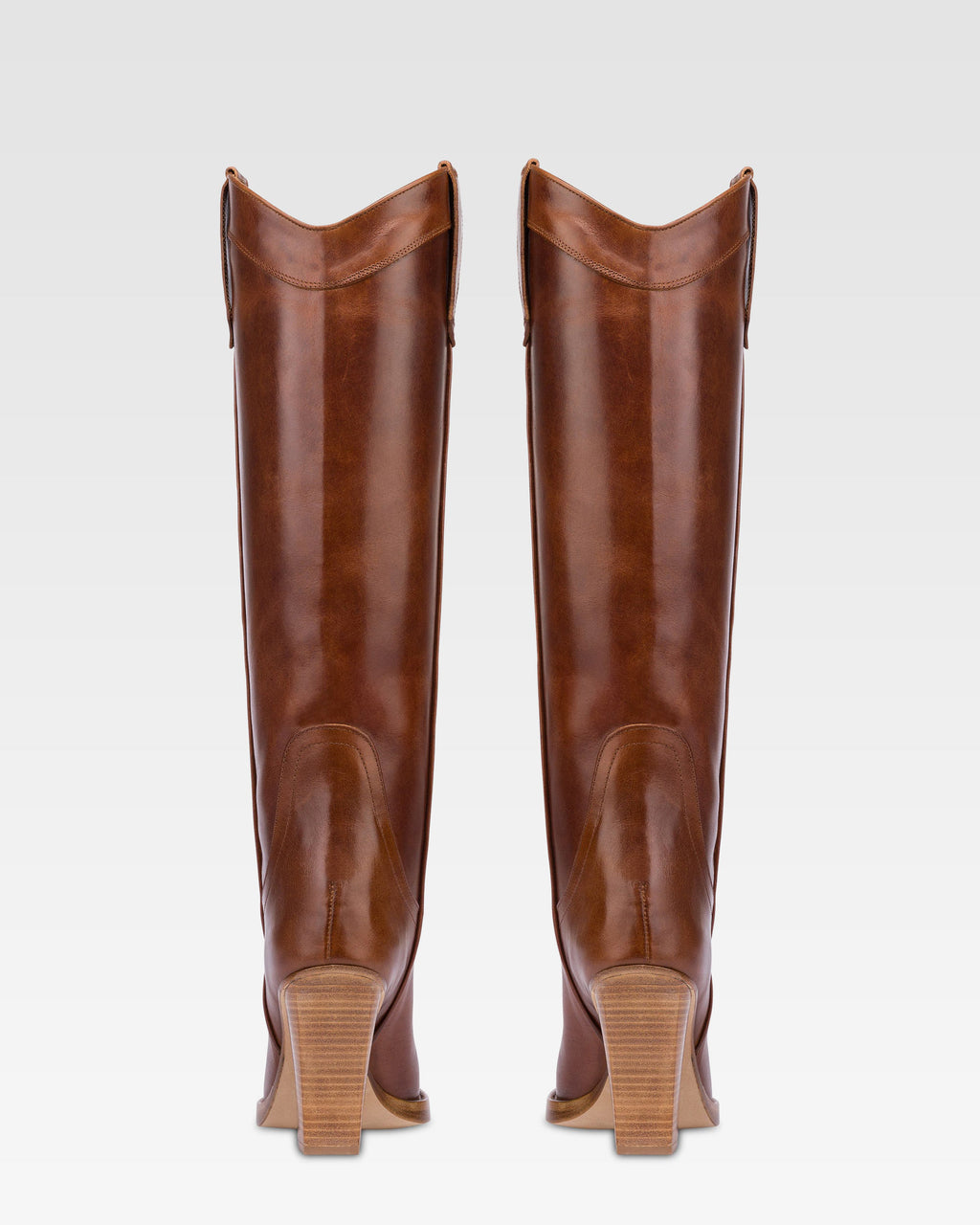 Pointed knee-high boots in shiny vintage leather