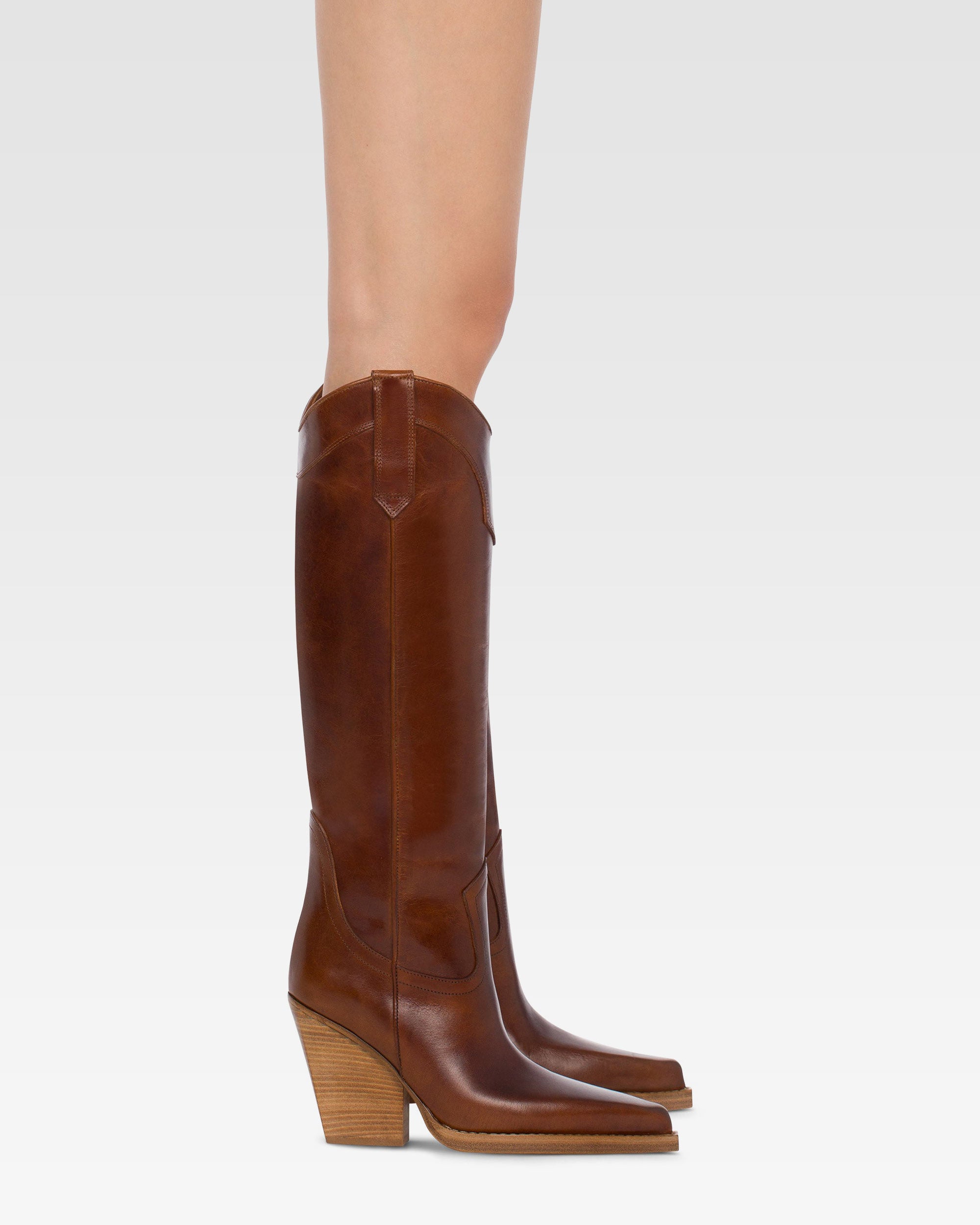 Pointed knee-high boots in shiny vintage leather